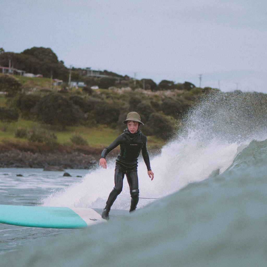 Person surfing on a wave with a coastal background